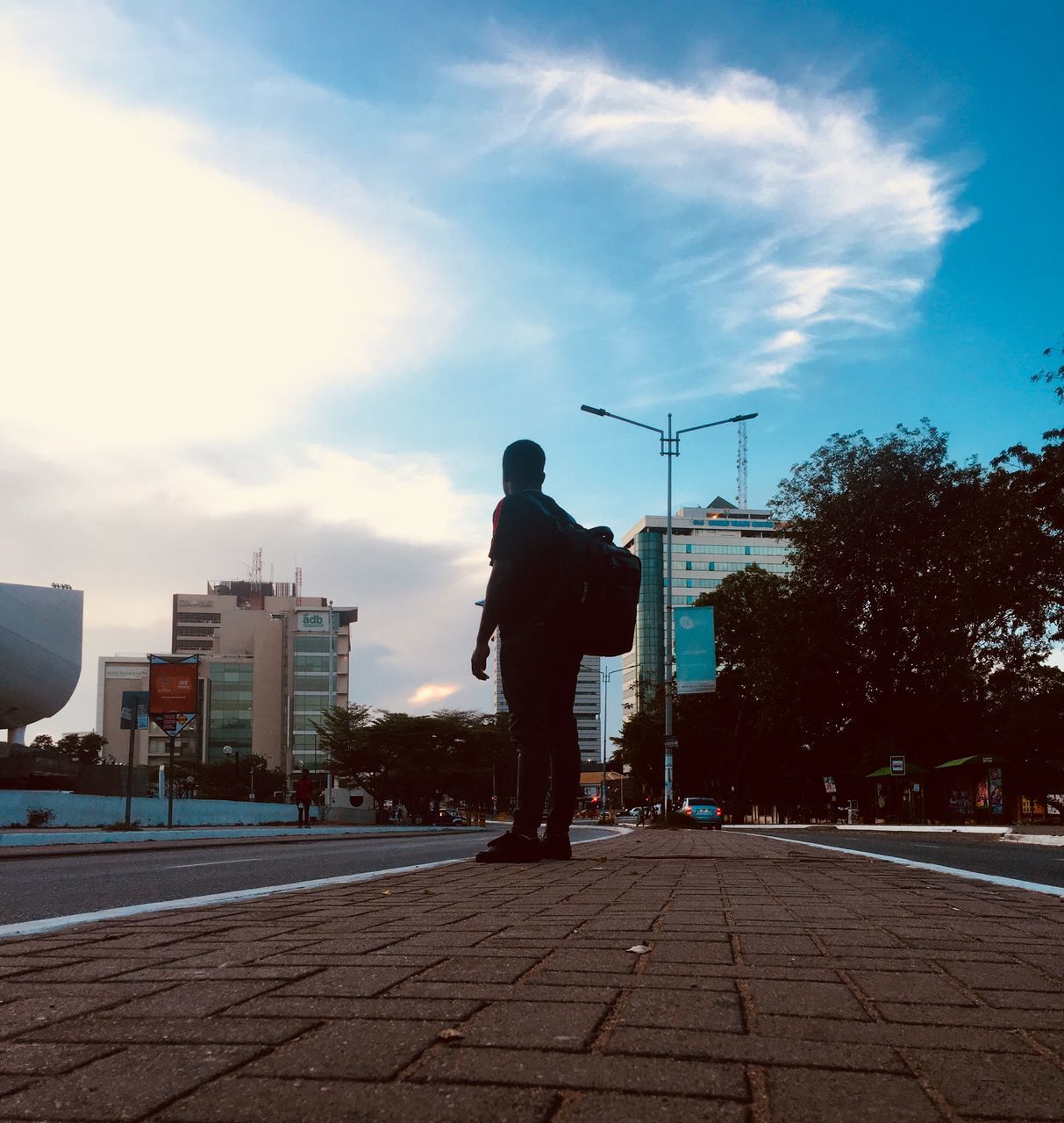 sky, one person, real people, building exterior, architecture, lifestyles, full length, men, city, built structure, leisure activity, street, rear view, nature, cloud - sky, footpath, standing, outdoors, sunlight