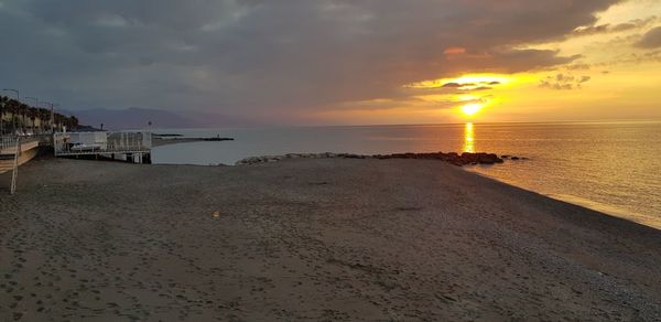 Scenic view of beach against sky during sunset