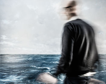 Blurred motion of man in sea against sky