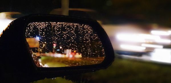 Close-up of illuminated lighting equipment on side-view mirror