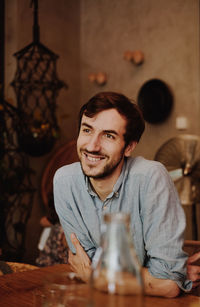 Portrait of a smiling young man sitting on table