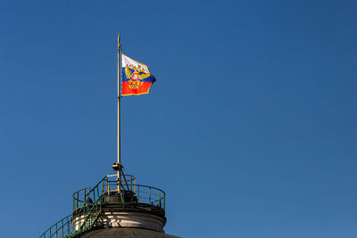 Low angle view of crane against clear blue sky