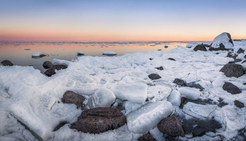 Scenic view of frozen sea against sky during sunset