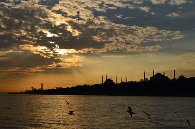 Calm sea with silhouette structures in distance