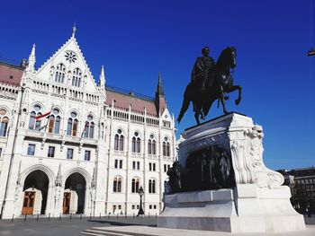 Statue of historic building against blue sky