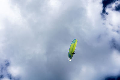 Low angle view of person paragliding against sky