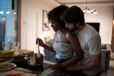 Young couple standing in kitchen at home