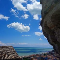 Scenic view of sea by buildings against sky