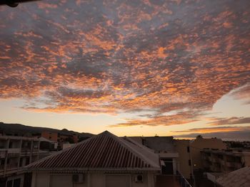 Townscape against dramatic sky during sunset