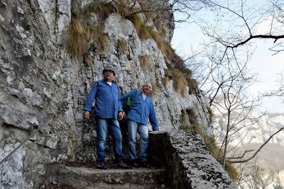 Men standing against rock