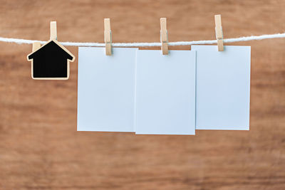 Close-up of blank notes hanging on clothesline wooden wall