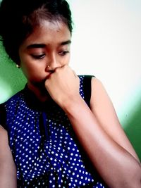 Portrait of young woman against wall