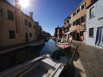 Canal amidst buildings in city against sky