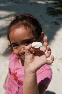 Close-up portrait of girl holding hands on beach