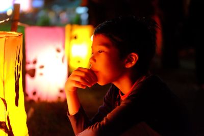 Close-up of boy looking at illuminated lantern