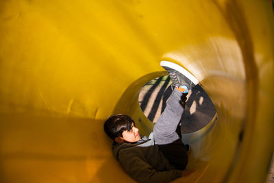 Portrait of boy in playground tube