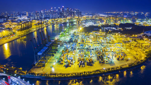 High angle view of illuminated buildings by river at night