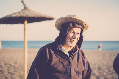 Close-up of senior man wearing hat while standing at beach