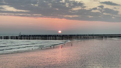 Pier over sea against sky during sunset