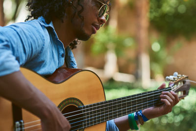 Midsection of man playing guitar