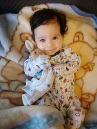 Portrait of cute baby lying on bed