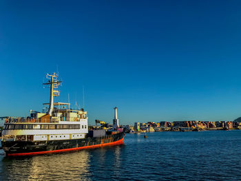 Ship in sea against clear blue sky