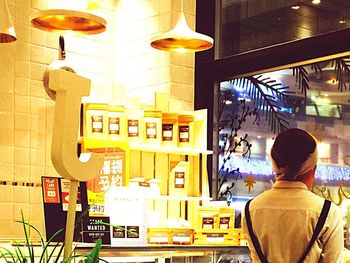 Rear view of woman using smart phone at store