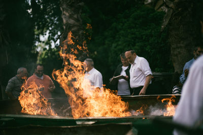 People standing by bonfire