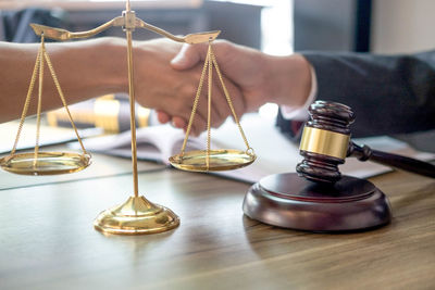 Cropped image of people shaking hands on table