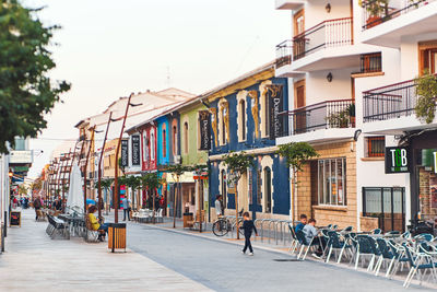 People walking on street amidst buildings in city