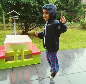 Full length of boy with arms raised against trees