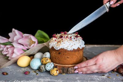 Midsection of person holding ice cream on table