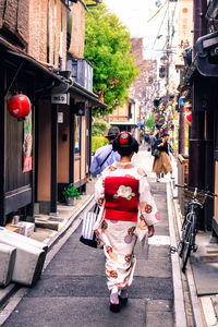 Rear view of woman walking on street in city