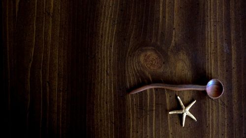 Full frame shot of wood with a starfish and wooden spoon on it