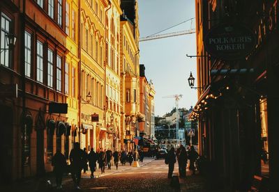 People walking on street amidst buildings in city