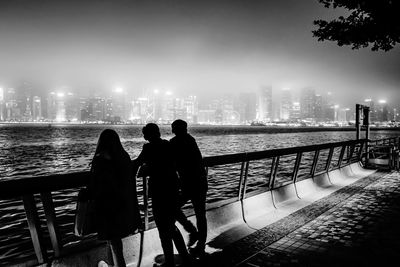 Rear view of people looking at cityscape against sky