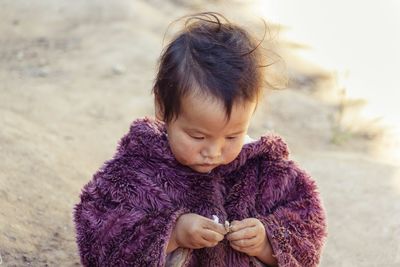 Baby hmong playing on dirty ground in chiang mai thailand