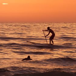 Full length of silhouette man on sea against sky during sunset
