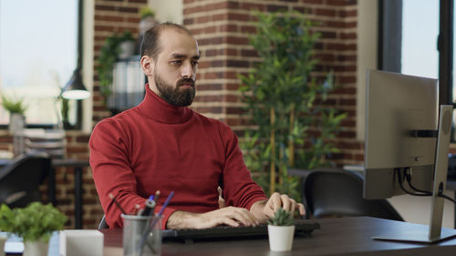 Businessman man using computer sitting at desk in office