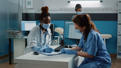 Doctor and nurse wearing mask working at medical clinic