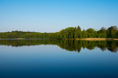 Scenic view of lake against clear blue sky