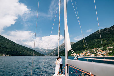 Man standing on sailboat against sky