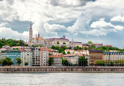 View of cityscape against cloudy sky