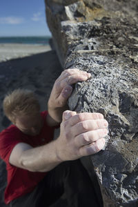 High angle view of man climbing rock at beach