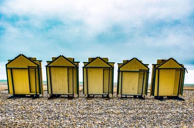 Row of houses on beach against sky