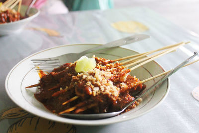 Close-up of food in plate on table. madura satay with a few slices of lime on the top