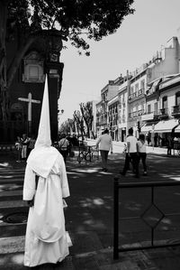 People walking on street in city against clear sky