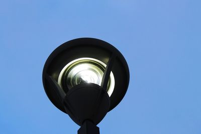 Low angle view of illuminated street light against clear blue sky