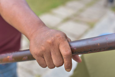 Close-up of hand holding metal railing