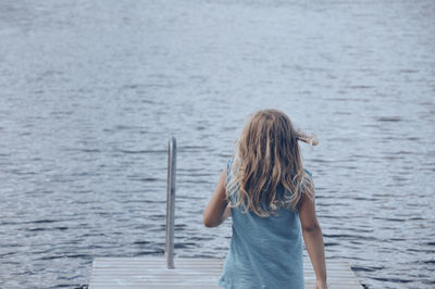 Rear view of woman standing in sea